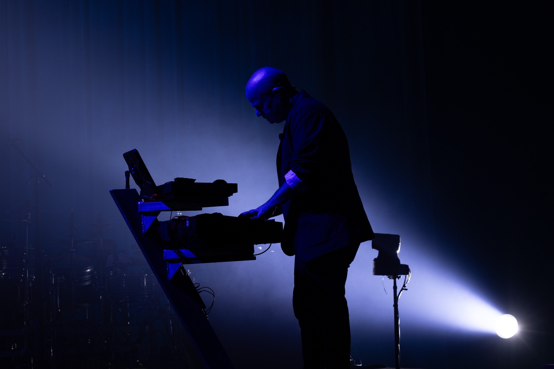Jason Halbert silhouetted at the keys under a single white spotlight